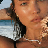 woman at the beach wearing waterproof jewelry and freshwater pearl necklace